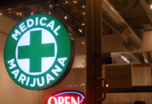 Image of a sign for a medical marijuana dispensary displayed on its front door.